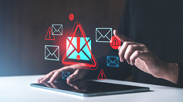Person with tablet in front of them and red exclamation points over email icons in the air