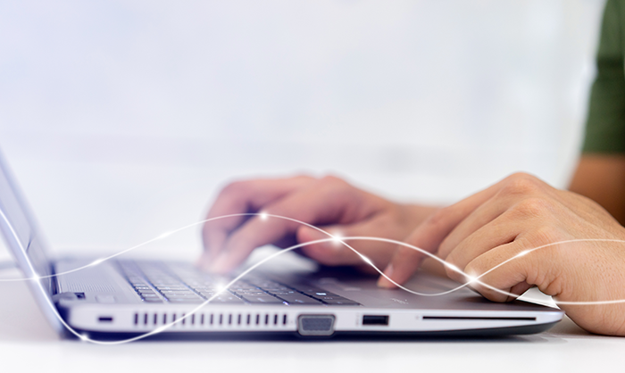 Person's hands typing at a laptop