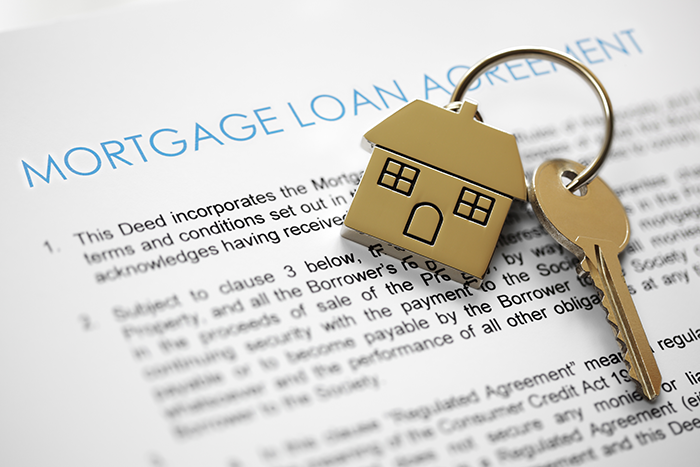 Mortgage Loan Agreement document with key on house keychain