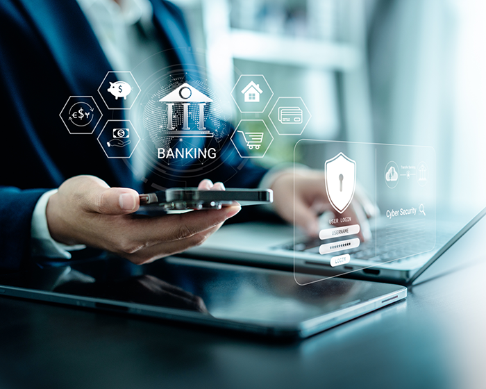 Man holding a phone next to a laptop with various online and mobile banking icons hovering above
